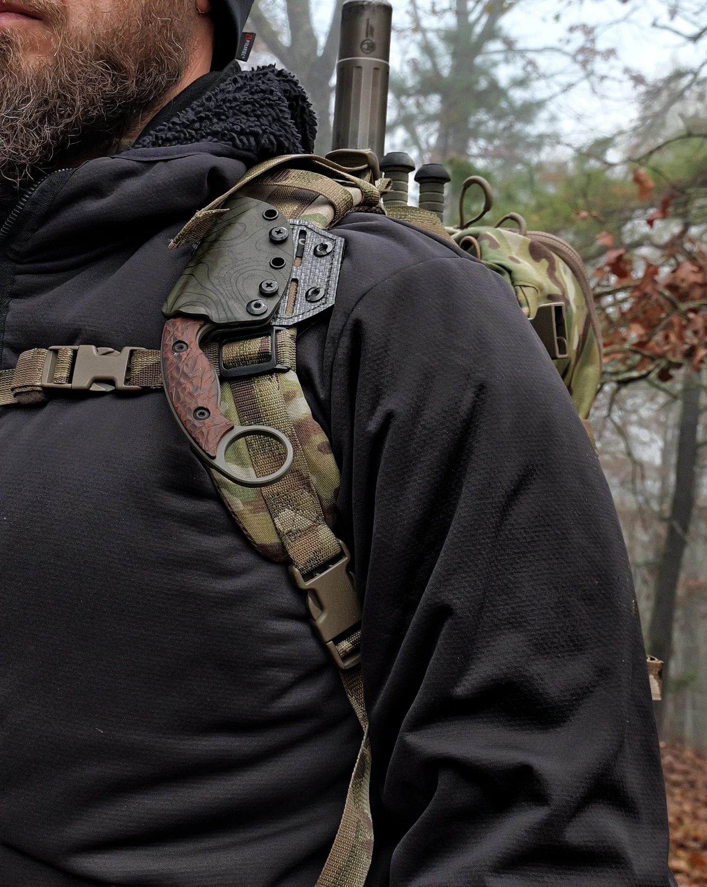 Karambit clipped to Eberlestock shoulder strap with suppressor visible over shoulder