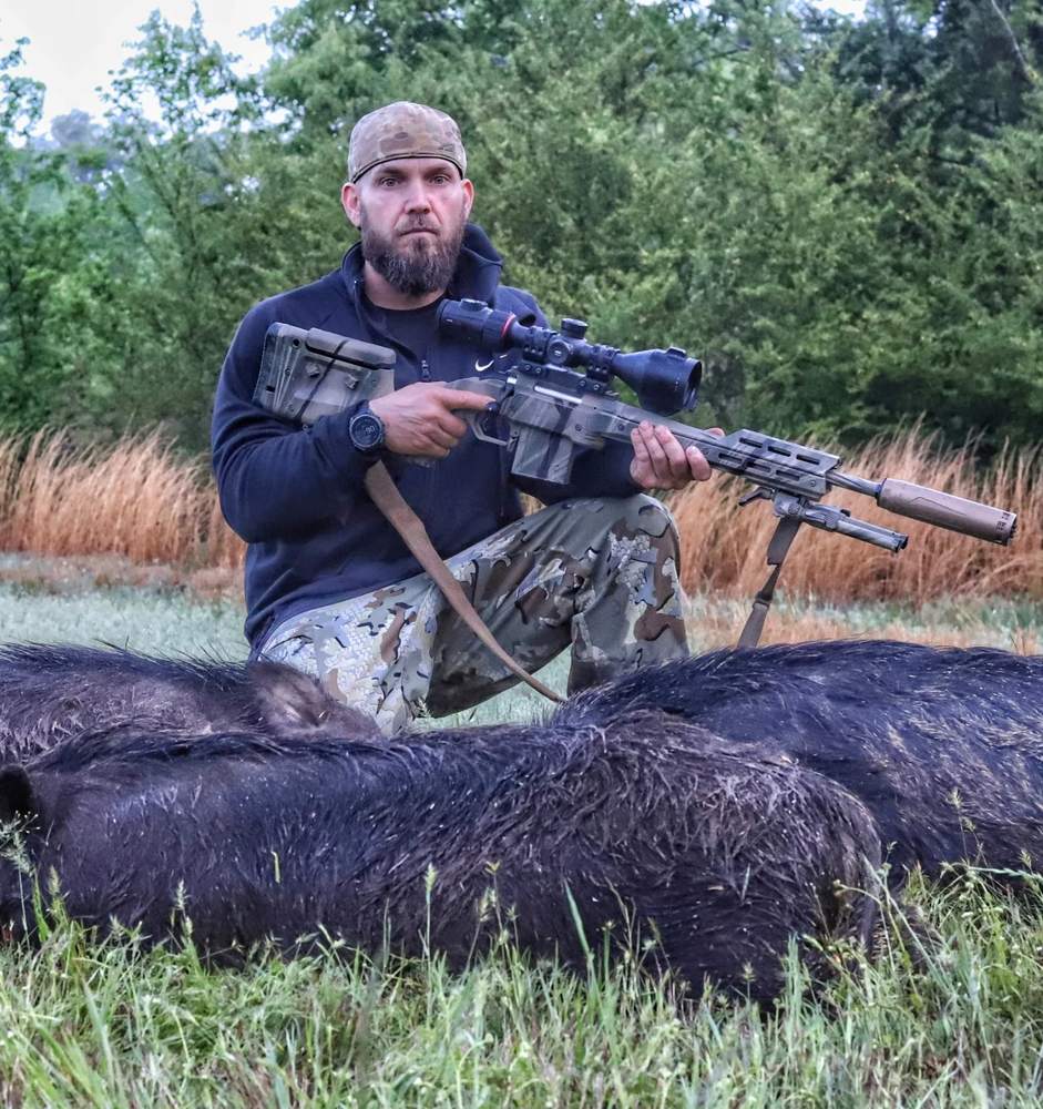 Three camo rifles staged at tailgate